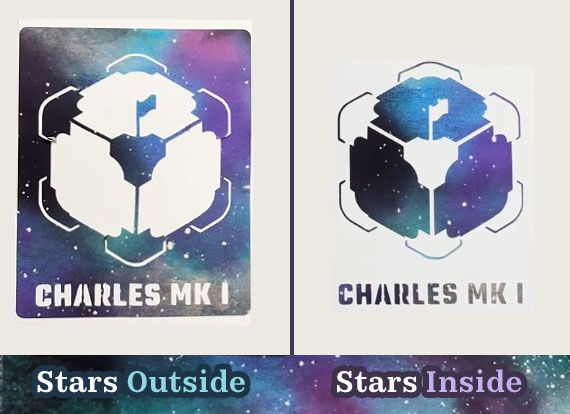 Two stickers are shown. The one on the left has a star design primarily cut outside a cube figure. The one on the right has the star design inside the cube figure. The cube has a tiny flag on it, and the name "Charles Mark One" underneath.