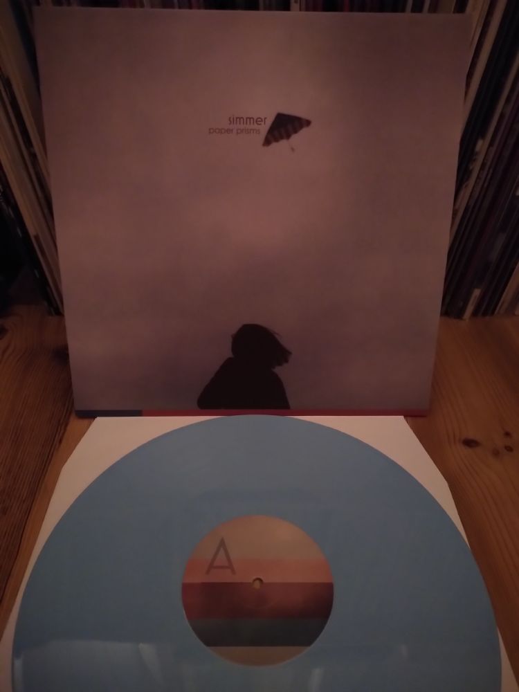 Cover der LP von Simmer - Paper Prisms (Himmel mit Silhouette einer Frau mit einem Drachen), blaue Vinyl 