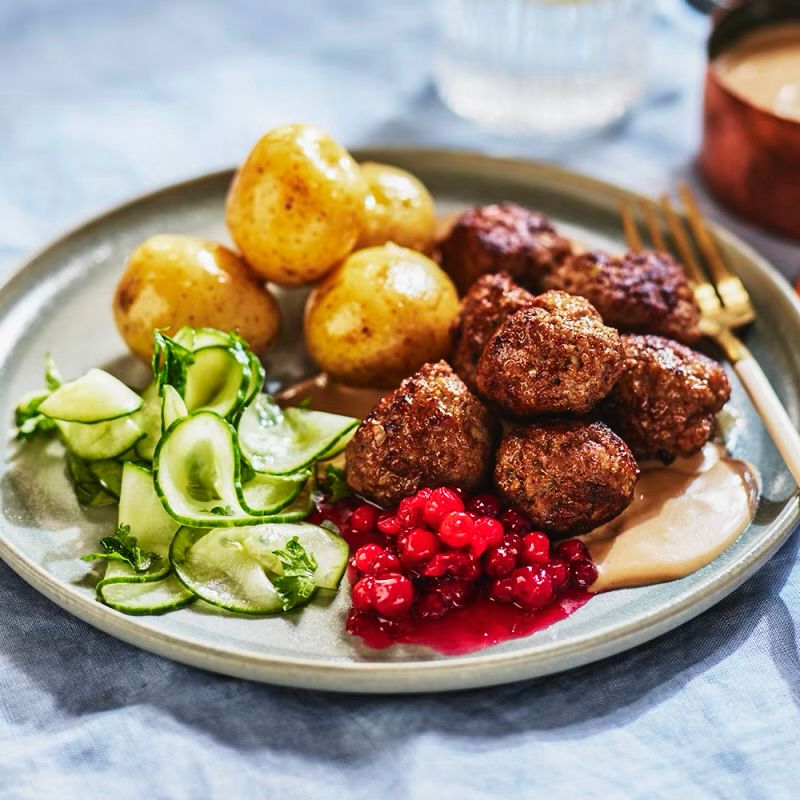 Meatballs, lingonberry jam, potatoes, pickled cucumbers and brown sauce