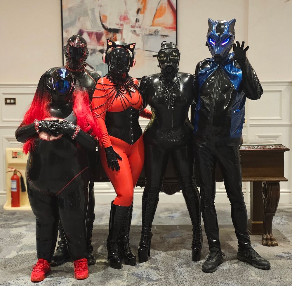 4 people in latex and gasmasks looking like drones 1 person as a  cyber wolf super cool 