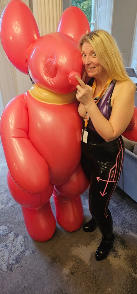 Lady in purple and black latex outfit with a large inflatable balloon dog