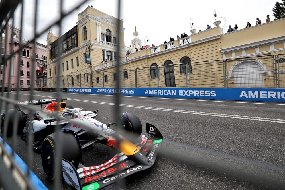Shot from behind the catch fence showing the VCARB02 accelerating out of T15 at the Baku City Circuit.