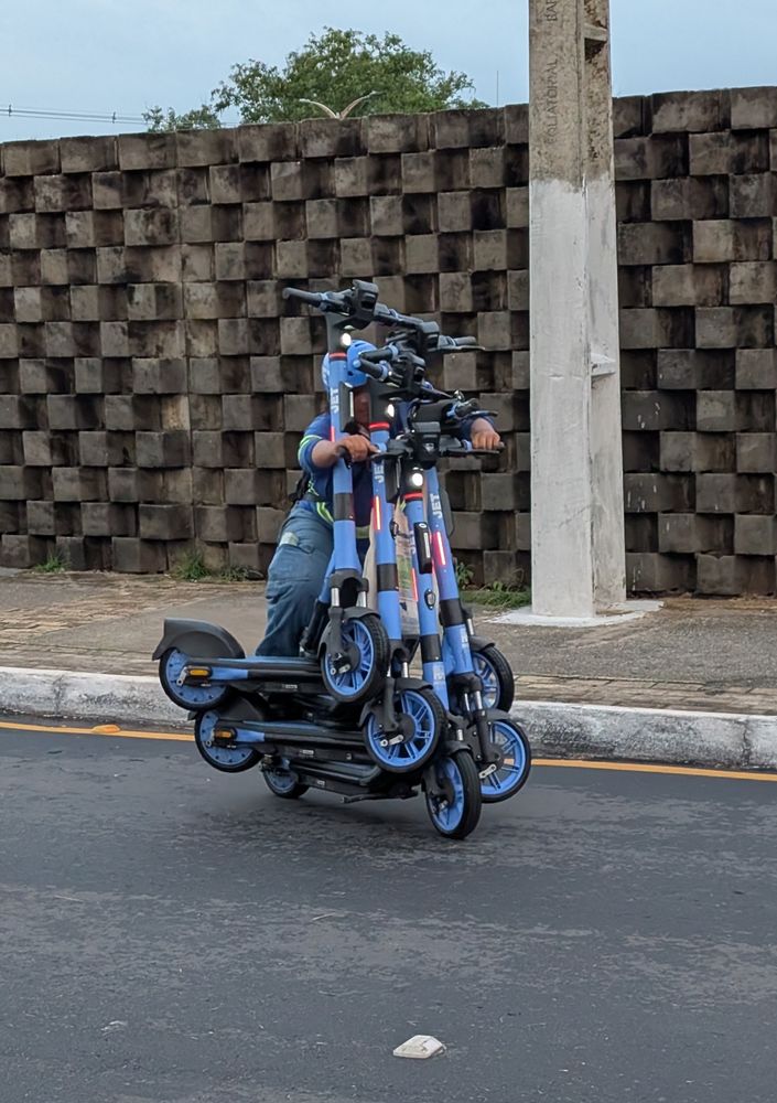 Person fährt auf fünf e-scootern gleichzeitig 
