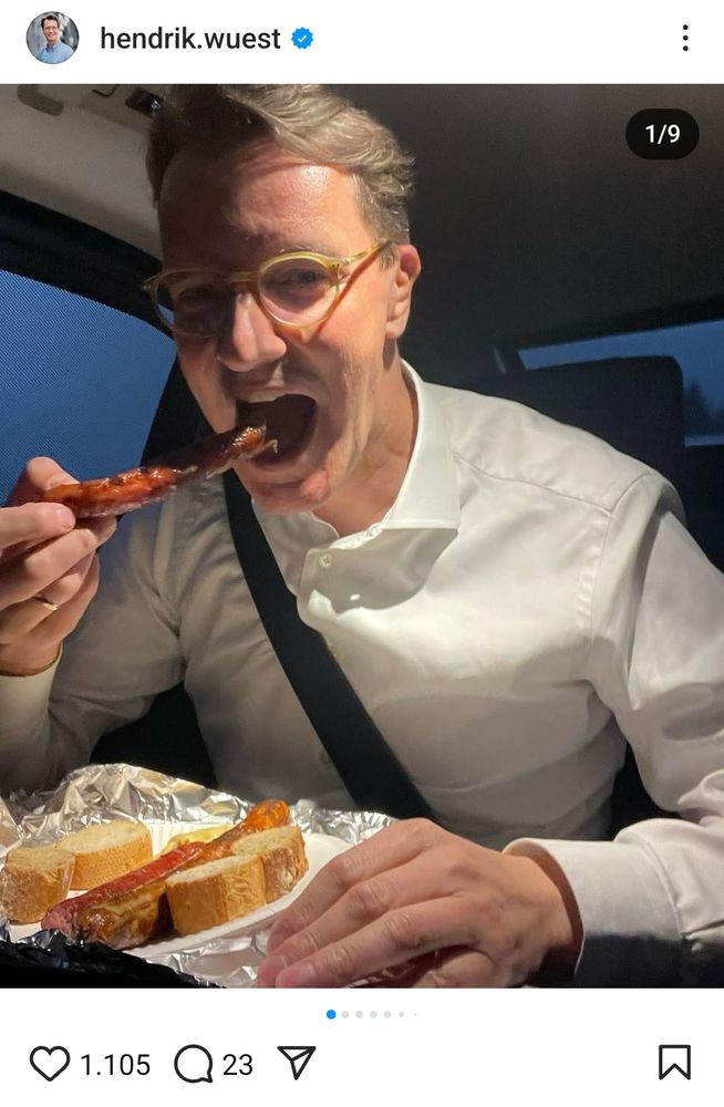 Hendrick Wüst schiebt sich eine Bratwurst zwischen die Kiemen
