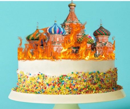 A birthday cake with a burning cathedral of st. basil 