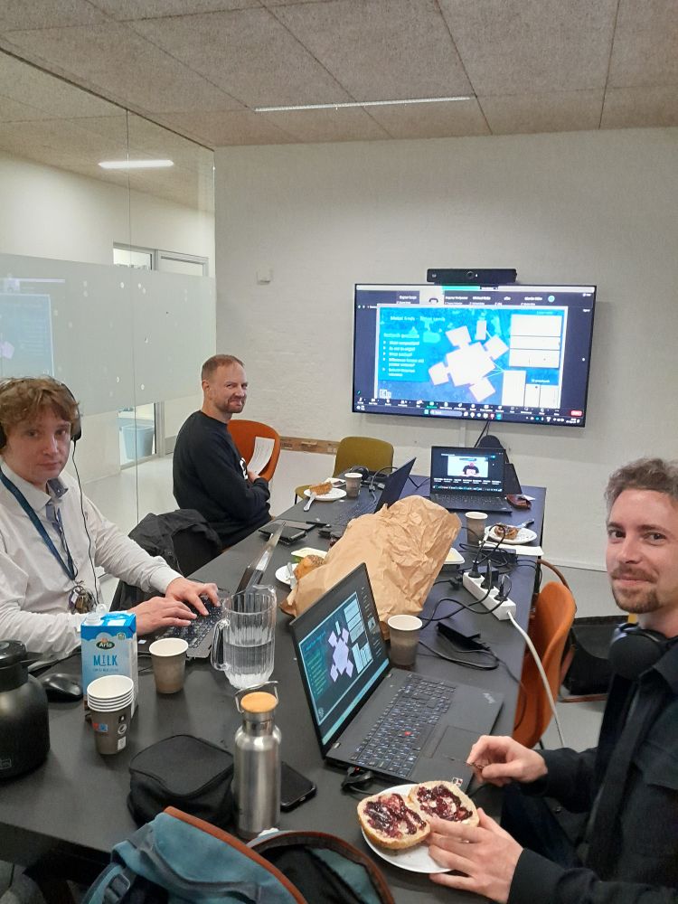 The meeting room of the Aarhus Hub is already full in the session, the latest presentation is on the screen and food is on the table.