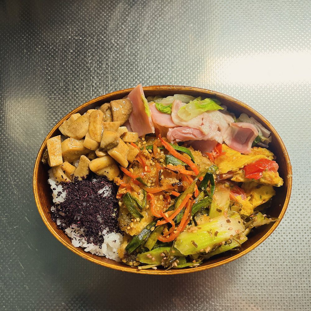 白菜とベーコンの酒蒸し、ミニトマトと粉チーズ入り卵焼き、セロリの塩昆布ナムル梅かつお風味、サバの唐揚げ油淋風、エリンギのオイスターソースマヨ炒め、ゆかりごはんの曲げわっぱ弁当