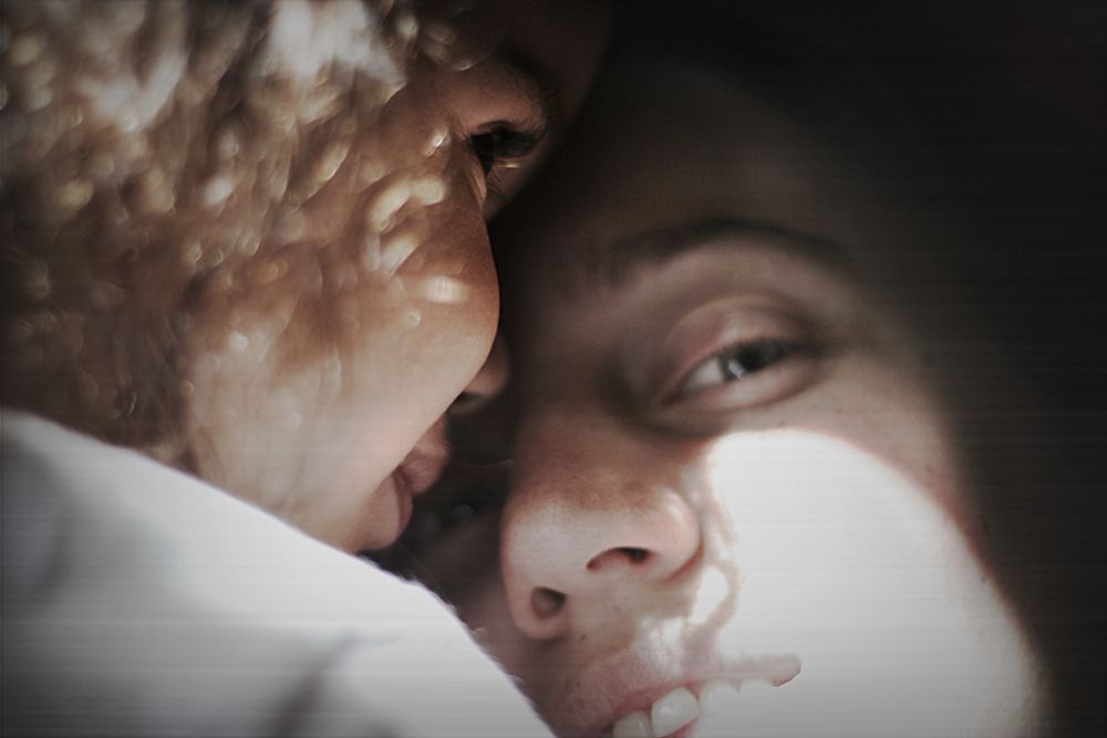 Woman’s face with a child’s face smooshed up close to her