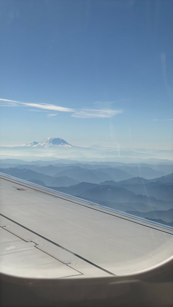 Out a plane window, mountains, sky and clouds