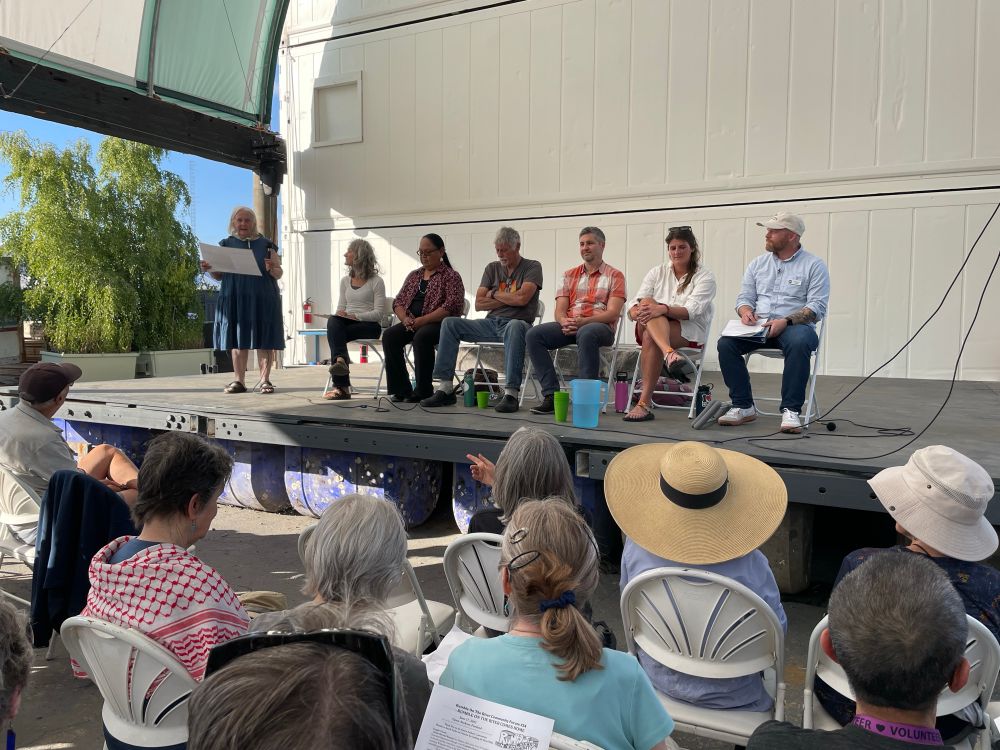 Panel of speakers on an outdoor stage 
