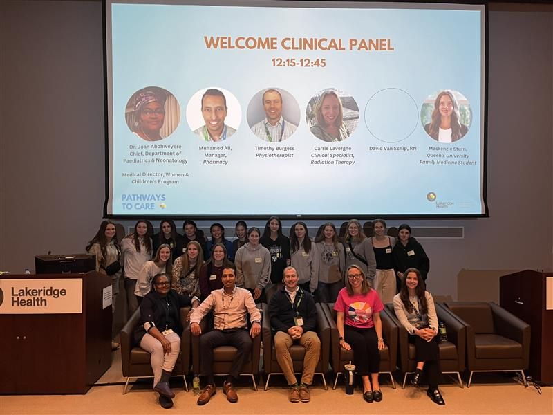 Panelists and students pose together on stage after the Pathways to Care clinical careers panel. A presentation slide behind them lists panelists from pharmacy, physiotherapy, radiation therapy, and medicine, representing a range of clinical career paths at Lakeridge Health.