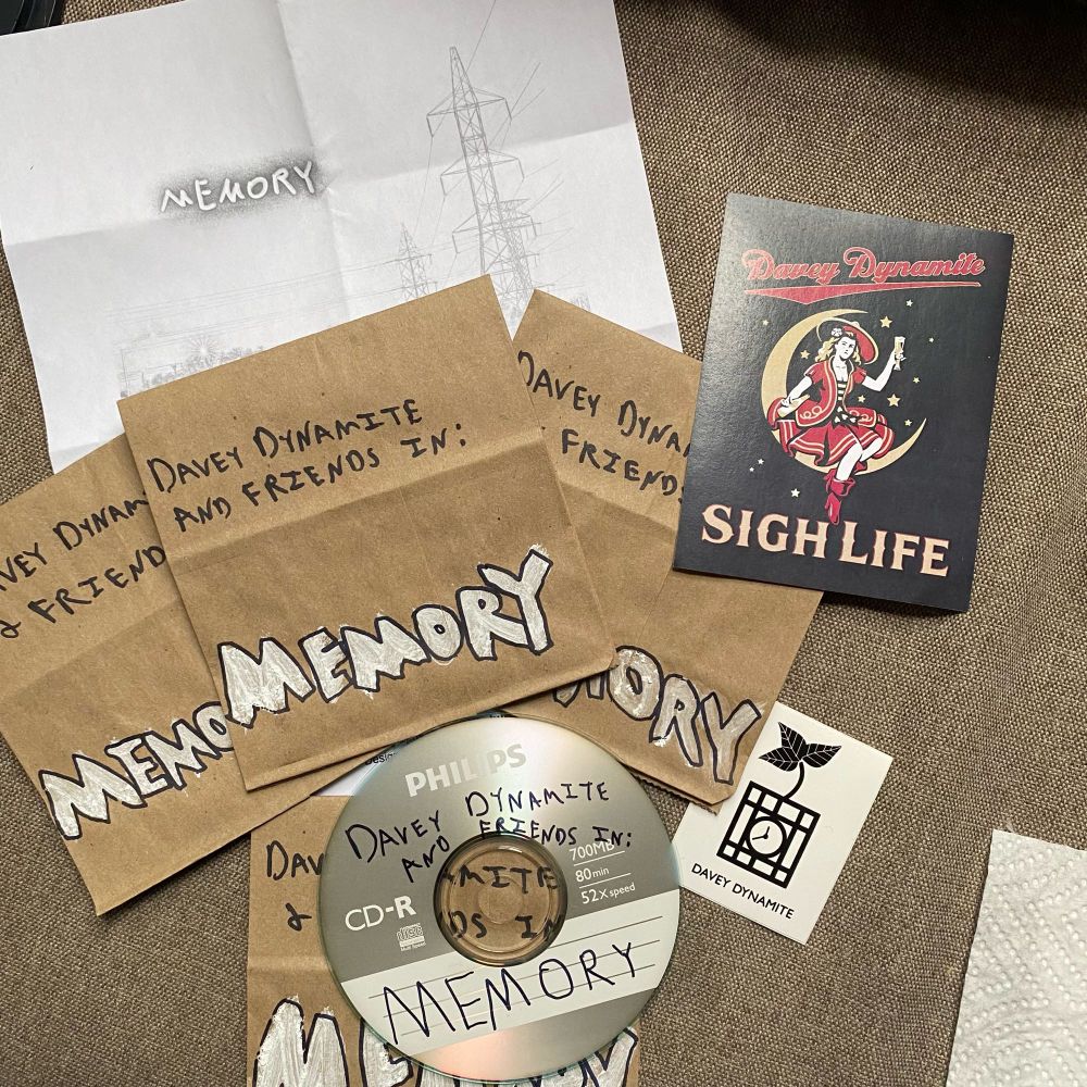 Painted/markered lunchbags and CD saying Davey Dynamite and Friends in: Memory. Two Davey D stickers, one with dynamite logo and one with miller high life design that says "sigh life". 