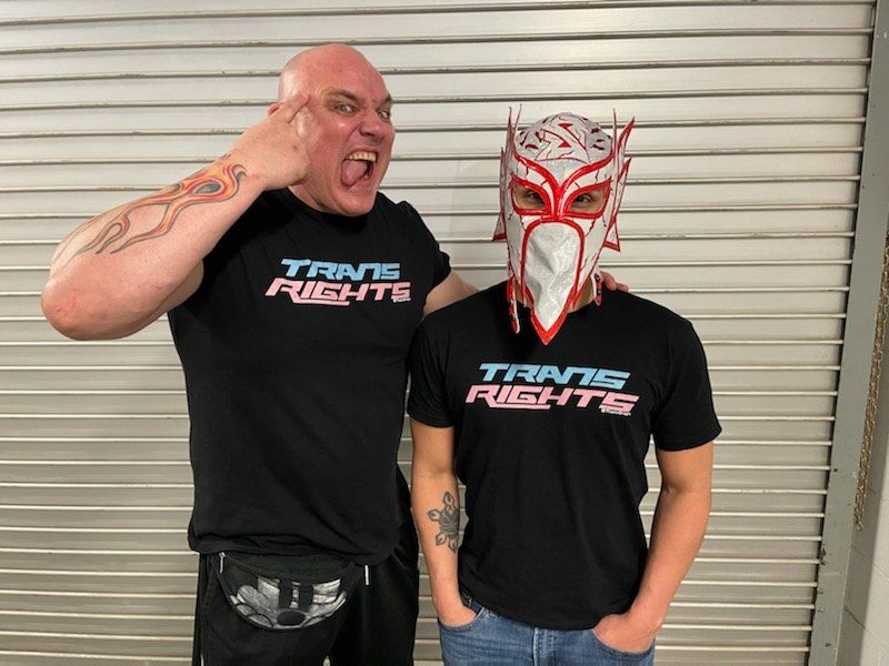 Luther and Serpentico, AEW Wrestlers, wearing black T-Shirts that say Trans Rights in blue and pink text