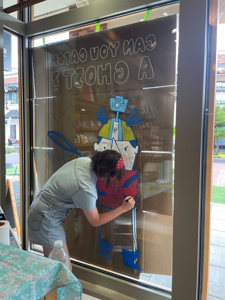 Rachel Michelle Wilson works on her window display at Brick & Mortar  Books.