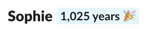 A screenshot of my name from Slack and a badge that says "1,025 years" with a confetti emoji