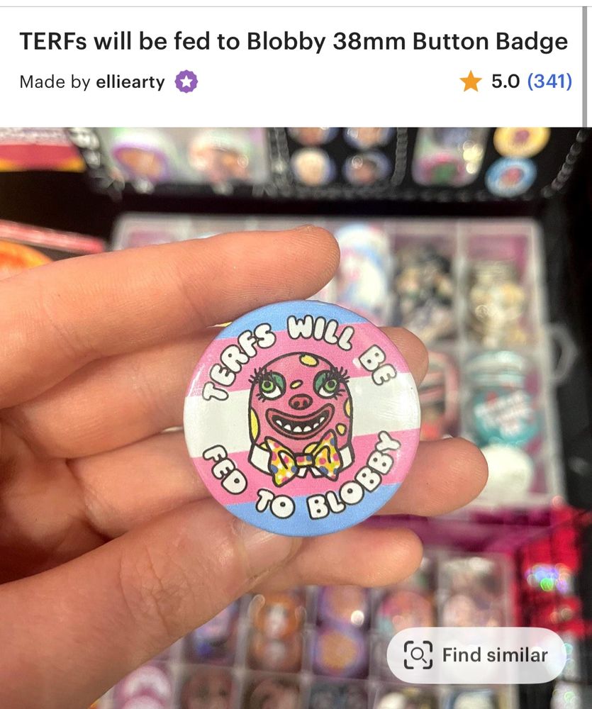 An Etsy screenshot: "TERFs will be fed to Blobby 38mm Button Badge". A hand holds up a circular badge with a trans flag background and the text TERFS WILL BE FED TO BLOBBY around an illustration of terrifying 90s uk tv mascot Mr Blobby 