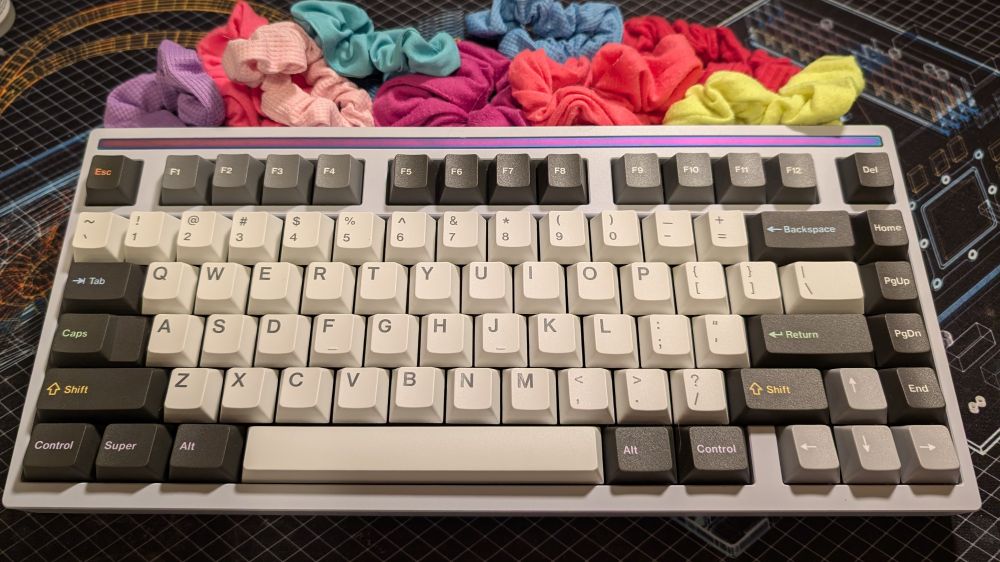 a mode sonnet keyboard on a deskmat with various hair scrunchies
