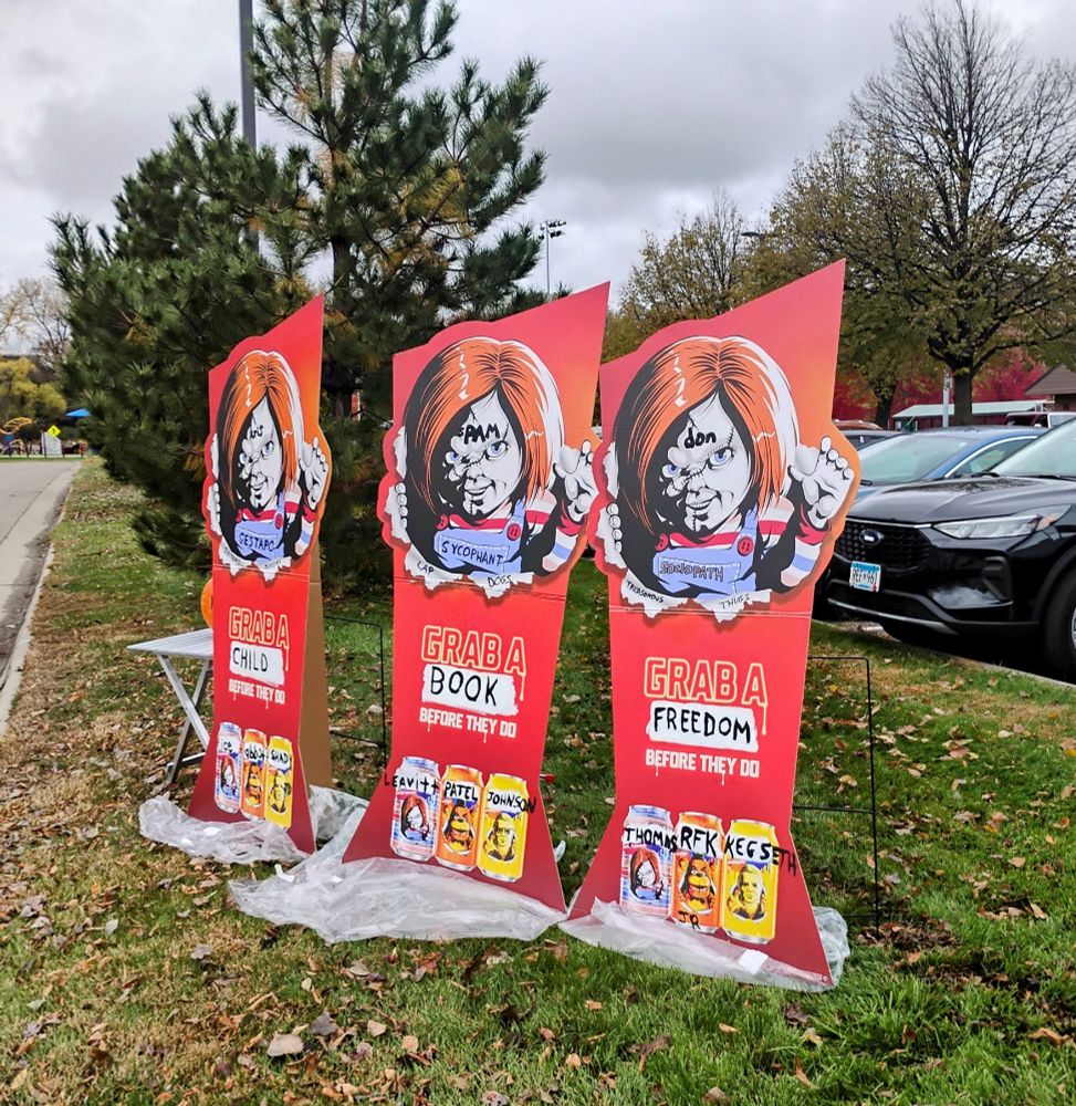 3 tall posters with Chucky labeled as Kristi, Pam and Don.  Respectively, they say ""Grab a child before they do" "Grab a book before they do" and 'Grab a freedon before they do" Other sycophants of the admiinstration are on the beer cans on the bottom. 