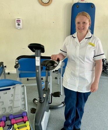 Dr Frances Butler standing alongside physiotherapy equipment in a hospital room.
