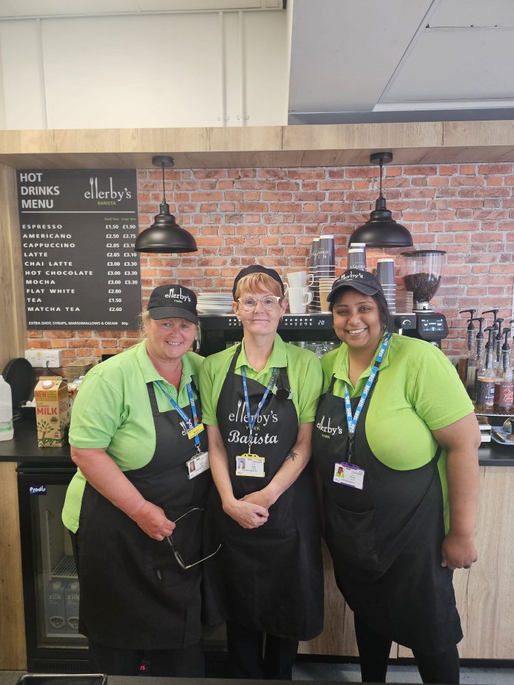 Three members of the team from Ellerby's barista standing together in front of the coffee station.