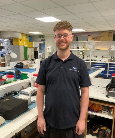 Ben in a workshop surrounding by engineering equipment.