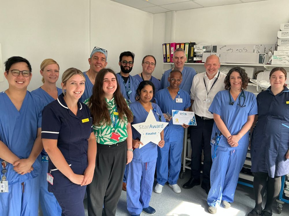 Mr Chintapatla and the wider team posing for a photo with Simon, Trust Chief Executive, after accepting a Star Award.