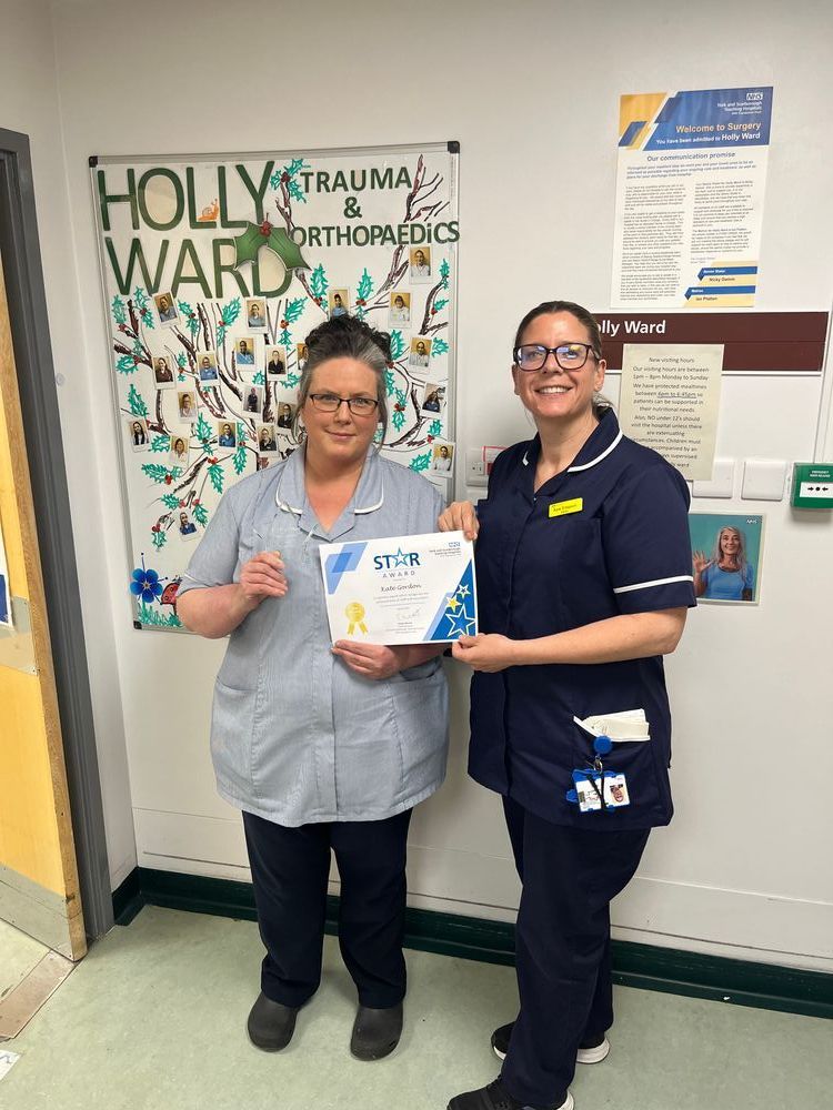 Kate holding her Star Award alongside a colleague.
