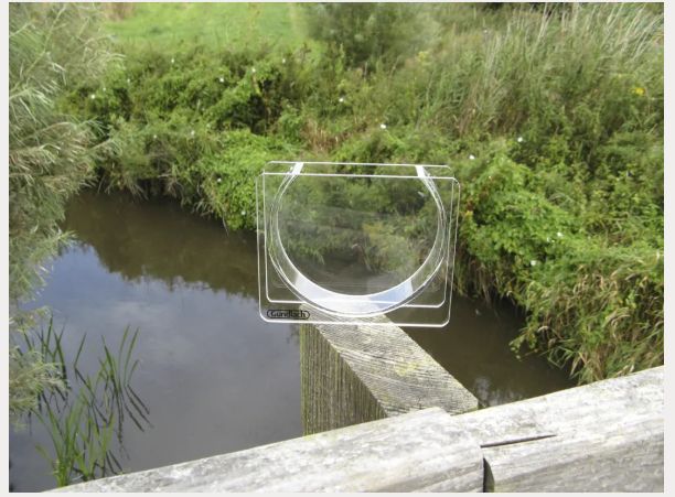 A narrow, tiny (10? cm) aquarium with rounded bottom made in acrylic. Image snagged from the website, which is https://www.frederiksen-scientific.no/produkt/demonstrasjonskyvette/761550 