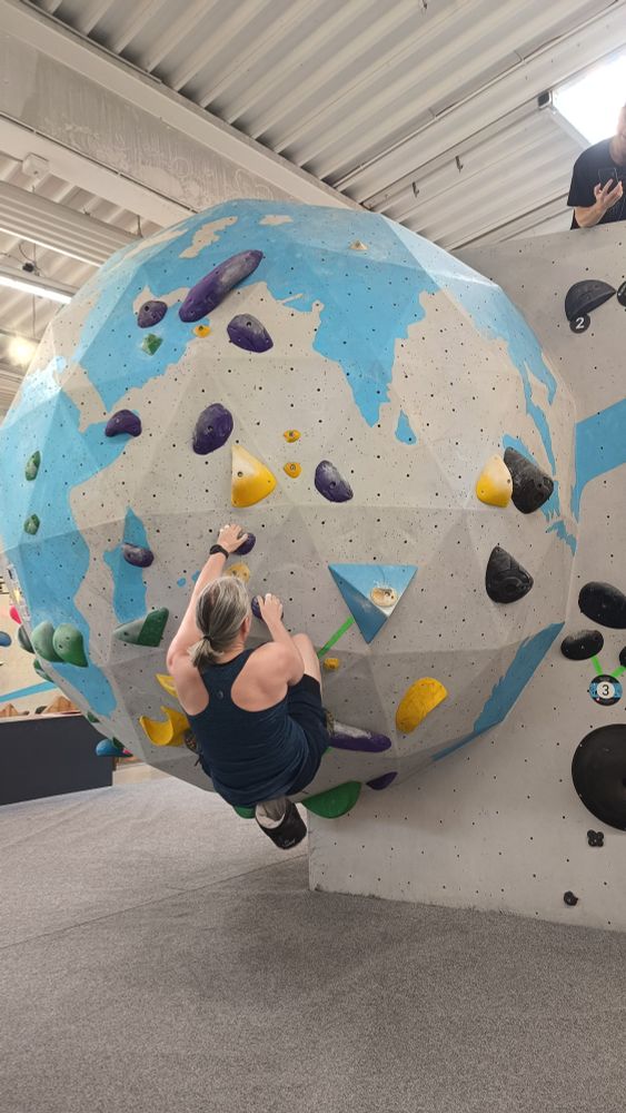 Me climbing up the mentioned route on the globe. Romses is visible up on the wall next to it.