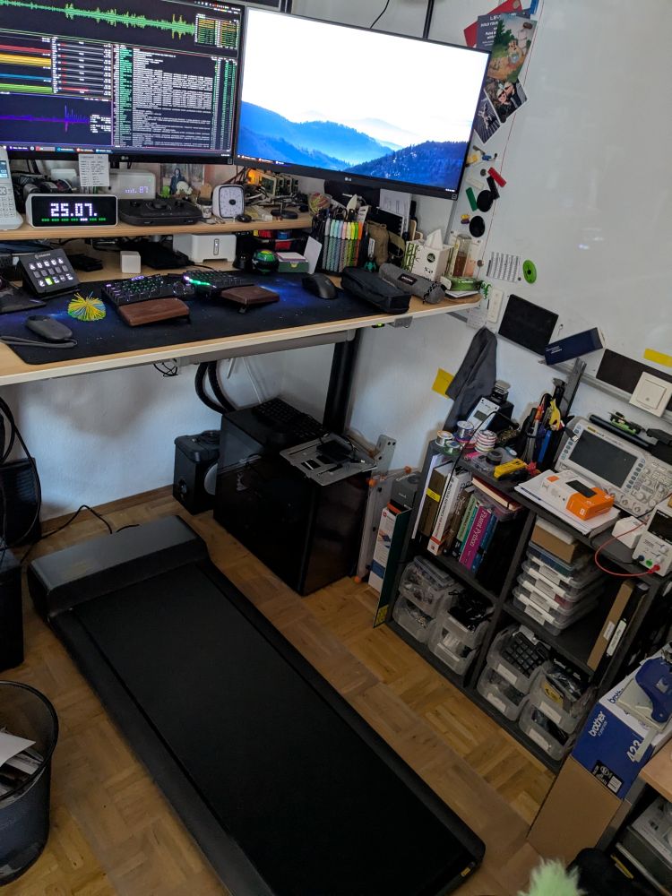 View of my office desk in standing mode, with a walking pad underneath.