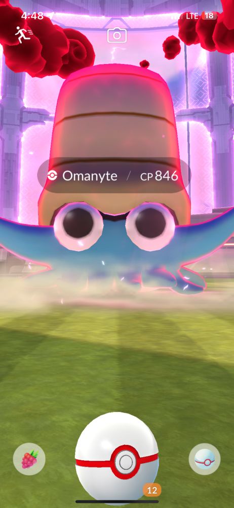 Screenshot from Pokemon Go showing dynamax omanyte, a blue nautiloid with huge cartoony eyes 