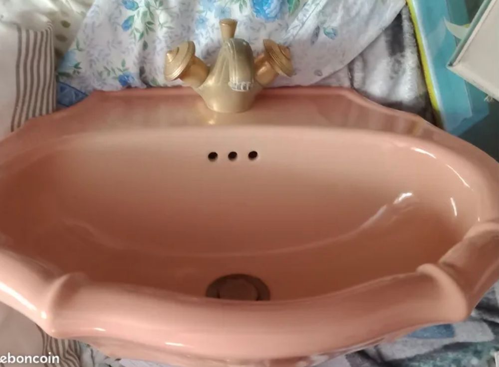 A vintage shellfish shaped salmon pink sink with a golden faucet, seen from different angles on the 4 pics
