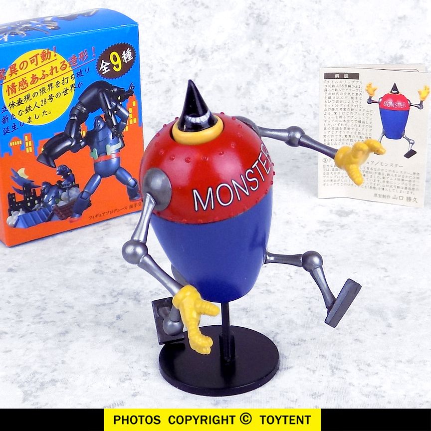 MONSTER robot from tetsujin 28 / gigantor, which is a big urn-shaped robot that has a pointy head with a toothy grin, and MONSTER written across its chest. its feet are big stupid paddles and it has goofy yellow hands