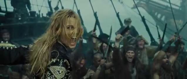 Film still from Pirates of the Caribbean, “At World’s End” of the Pirate King (Elizabeth Swann) screaming “Hoist the colors!” to rally her crew and the other ships. 