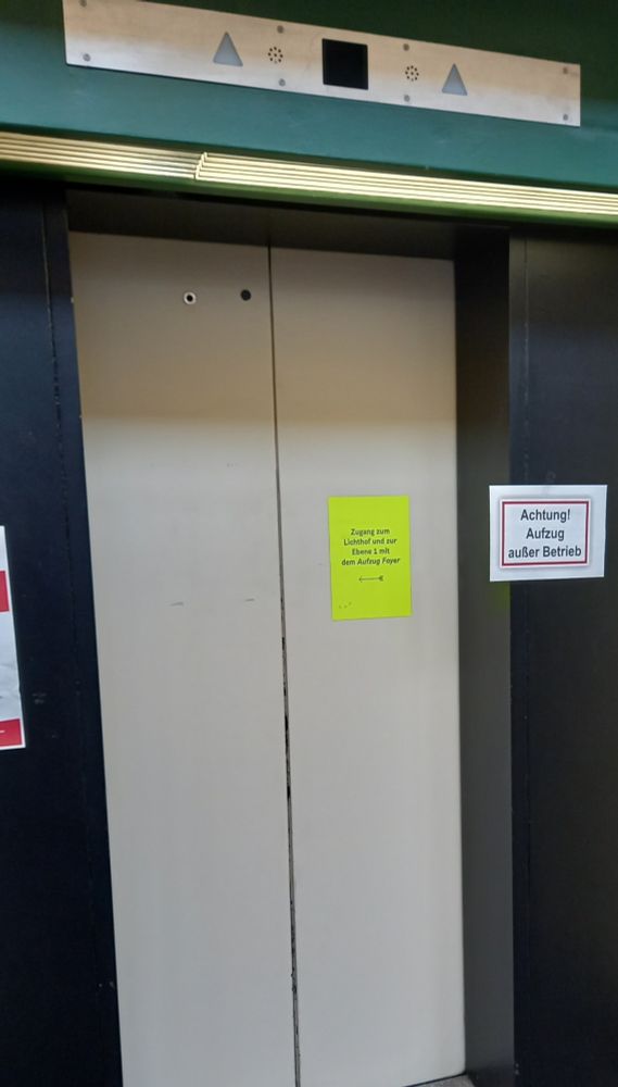 Einer der drei Hauptaufzüge im Hauptgebäude der TU Berlin. Neben ihm ein Schild mit der Aufschrift: Achtung! Aufzug außet Betrieb.
