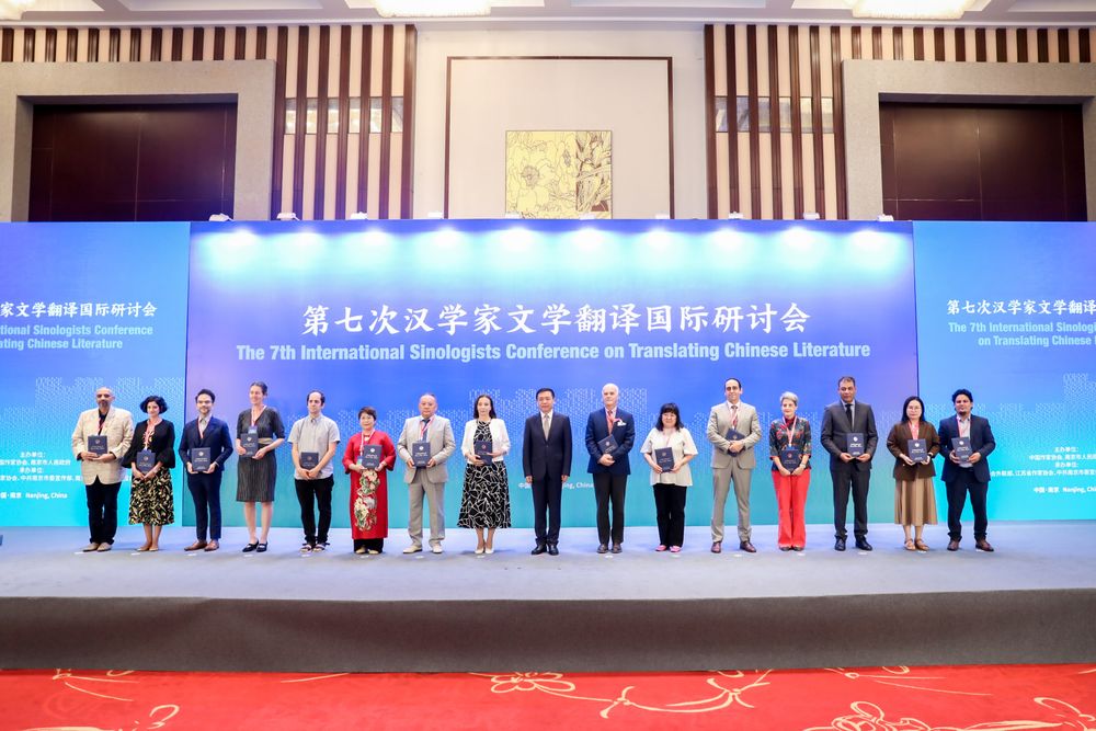 Stuk of vijftien sinologen op een podium poseren met hun Friend of Chinese Literature-certificaat dat ze zojuist uitgereikt hebben gekregen. Vierde van links ben ik. Op de achtergrond de titel van het evenement: 7th International Sinologists Conference on Translating Chinese Literature.