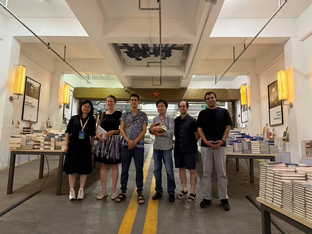 Zes mensen poseren bij de ingang van boekwinkel Librairie Avant-Garde. 2e van links ben ik, 4e van links A Yi.
