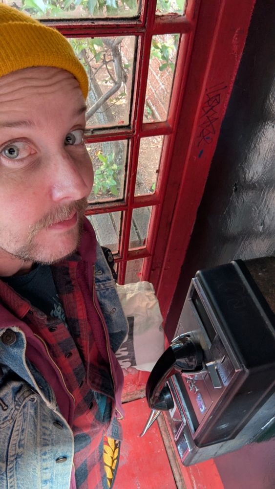 Kori in a phone booth waiting to chat with you about how we can work together.