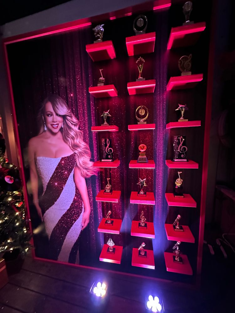 Mirag Carey wall print next to a display of… 18??awards