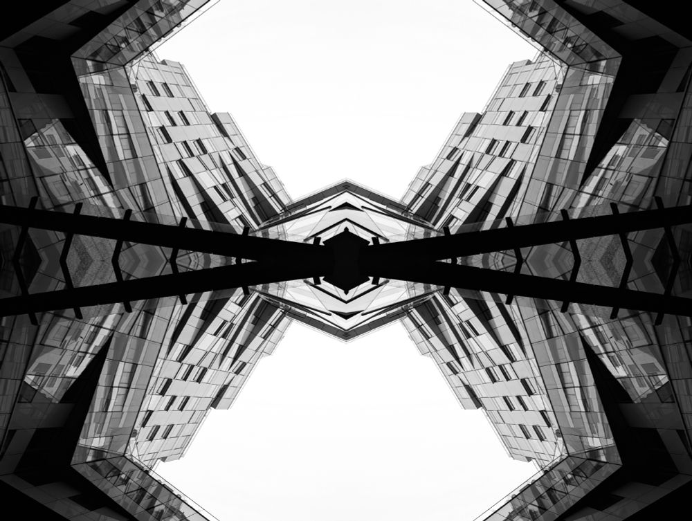 An abstract black and white photo of the Cube building in Birmingham, UK. It's been reflected both horizontally and vertically to create a perfectly symmetrical pattern. 