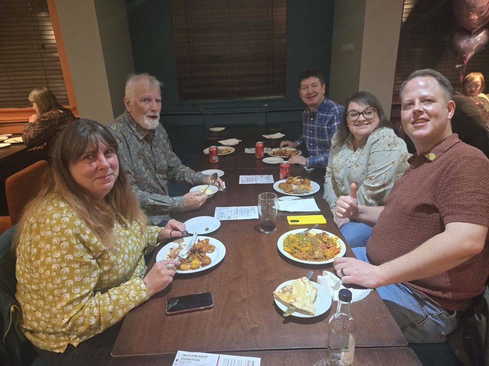 Members of Peterborough green party sitting around a dinner table, talking over dinner