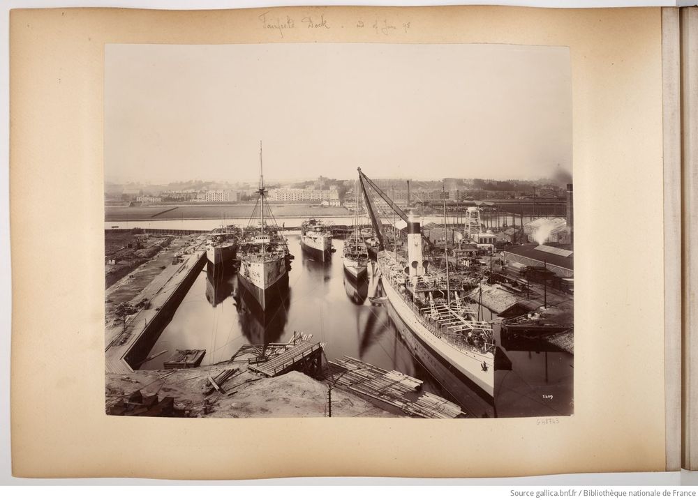 Photograph dated "June 1898", looking across a shipyard basin containing five partly fitted-out ships.