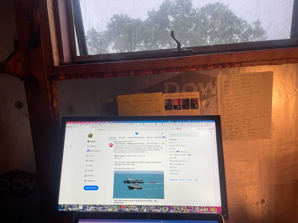 Photo of a computer screen displaying the bluesky website & above the screen, a skylight. 