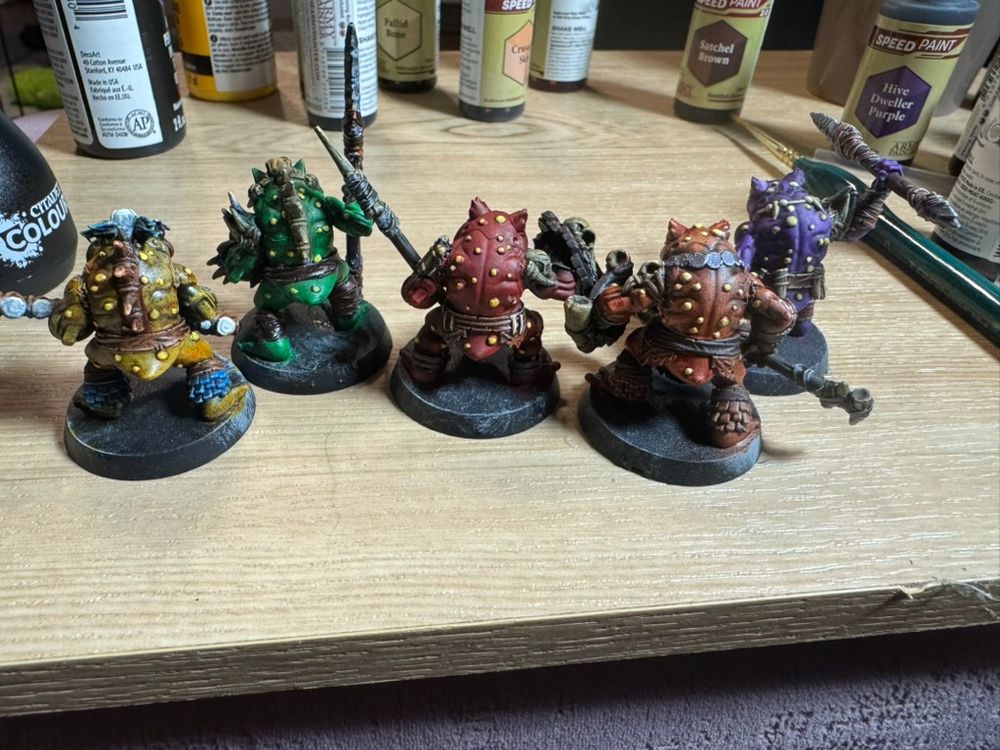 Five multicoloured frog infantry miniatures from the back.