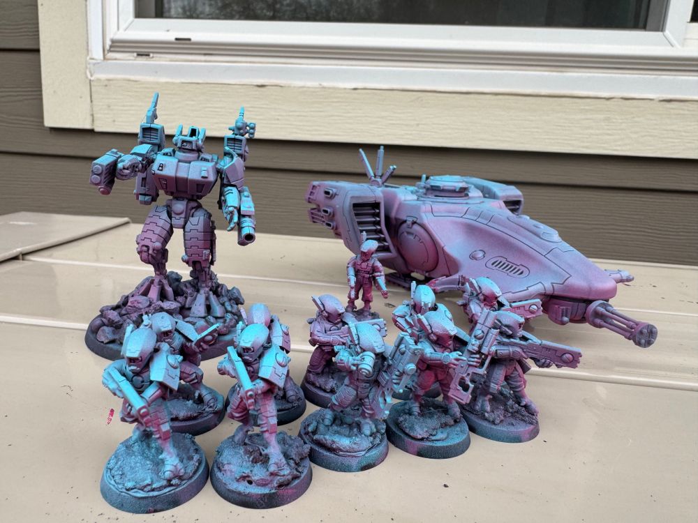 A Tau Commander, Fire Warrior squad, and a Devilfish APC primed with a pink to light blue gradient.