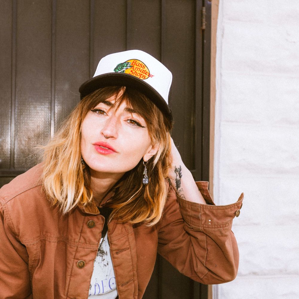 A woman wearing a hat that says Bass Amateur Shops, a parody of Bass Pro Shops
