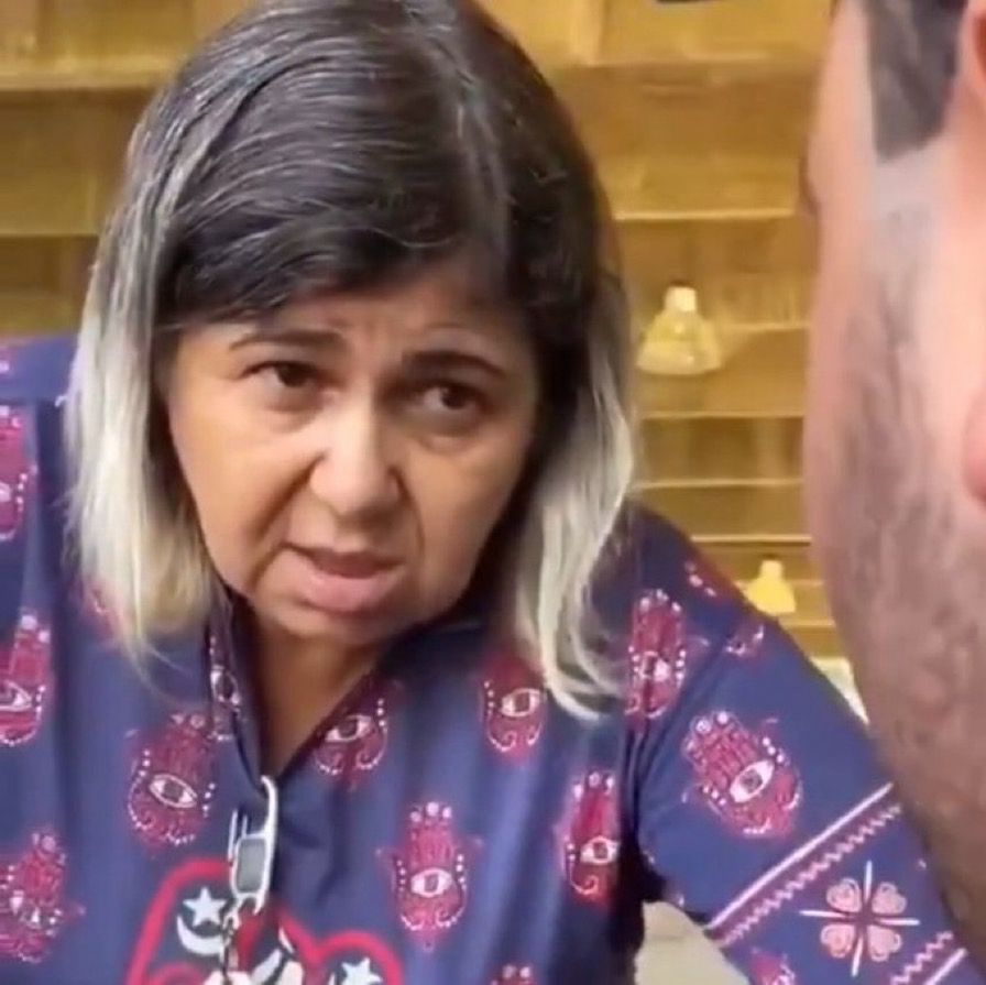 Mulher de cabelo bicolor respiradora bucal encara o interlocutor que não se encontra por completo na foto 
