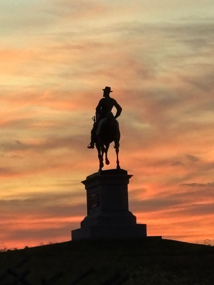 Gettysburg, PA. Statue of a military officer on horseback with sunset behind it.  