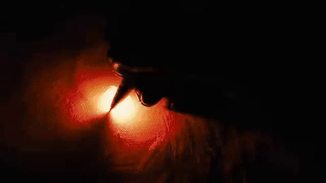 a close up of a person 's mouth in a dark room with a light coming out of it .