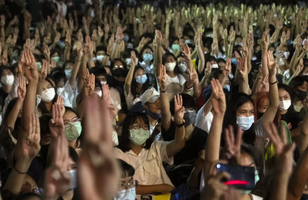 Picture of the crowd at the rally holding up 3 fingers. 